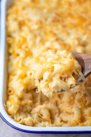 Wooden spoon scooping up baked mac and cheese