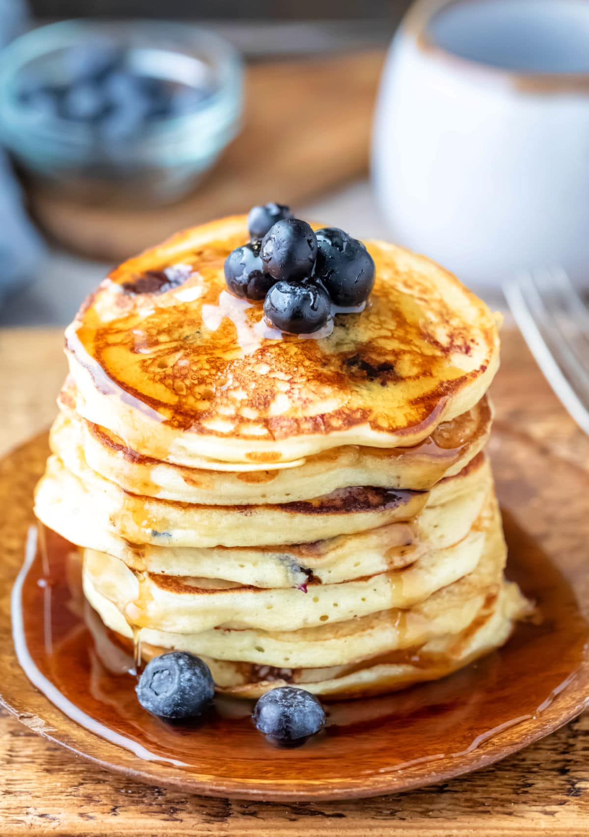 Stack of blueberry pancakes with maple syrup dripping off