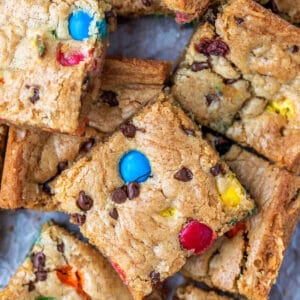 Stack of M&M cookie bars on a piece of parchment paper