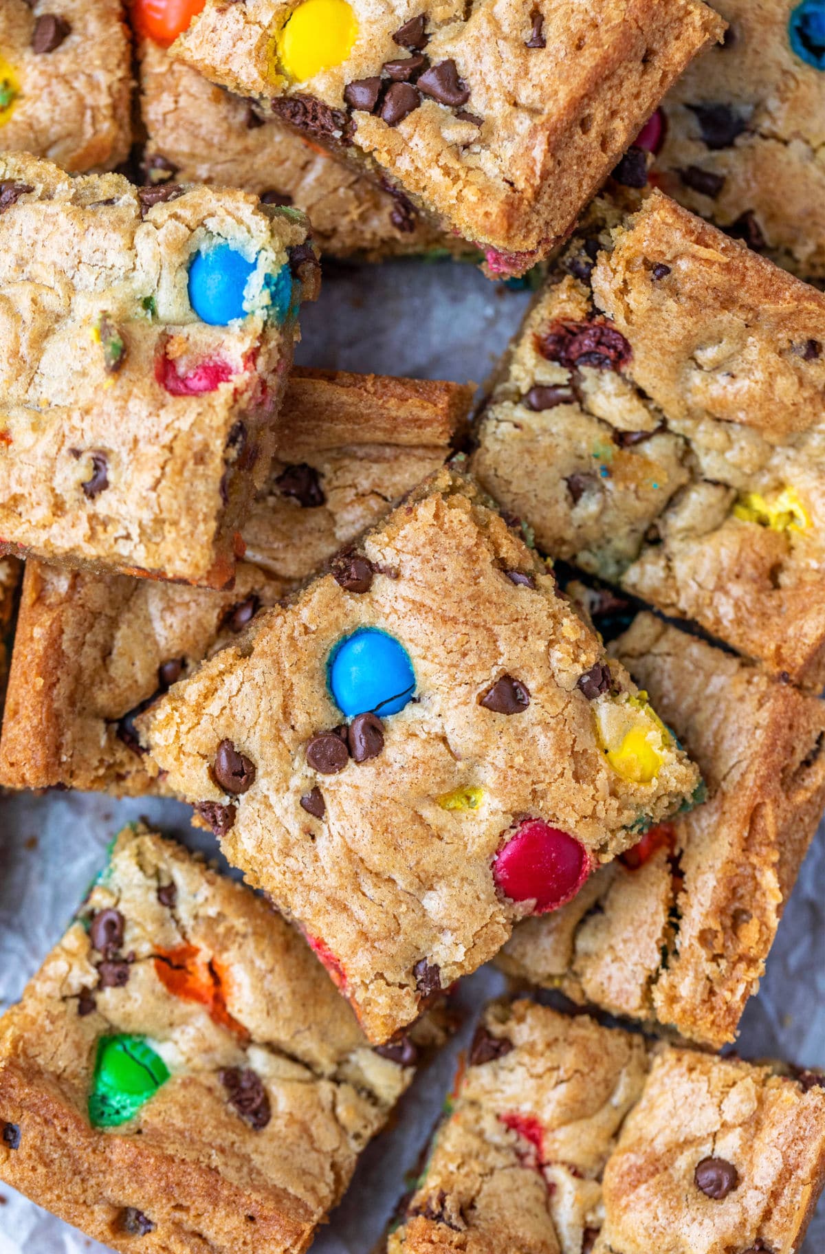 Stack of M&M cookie bars on a piece of parchment paper