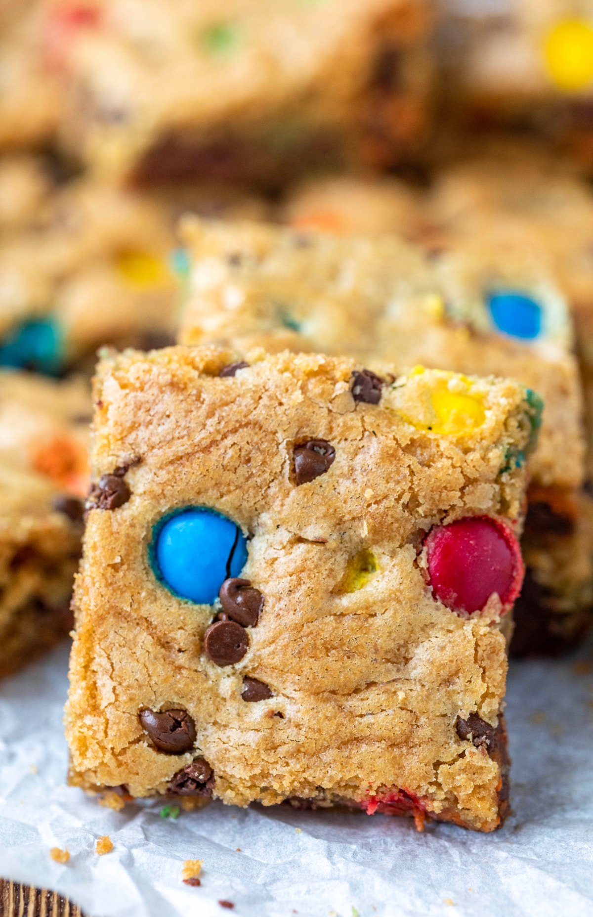 M&M cookie bar standing up next to a stack of cookie bars