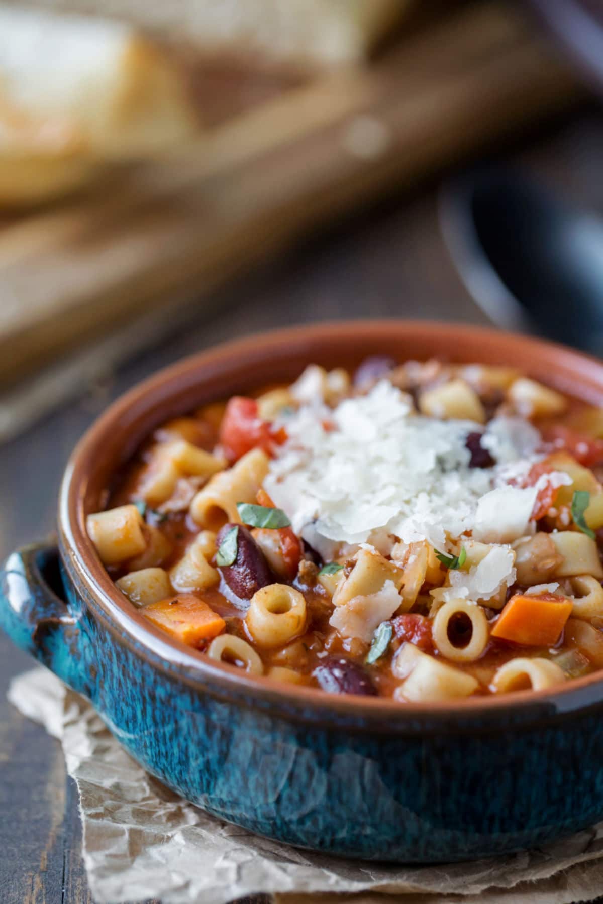 Pasta e Fagioli Soup topped with parmesan cheese in a blue bowl