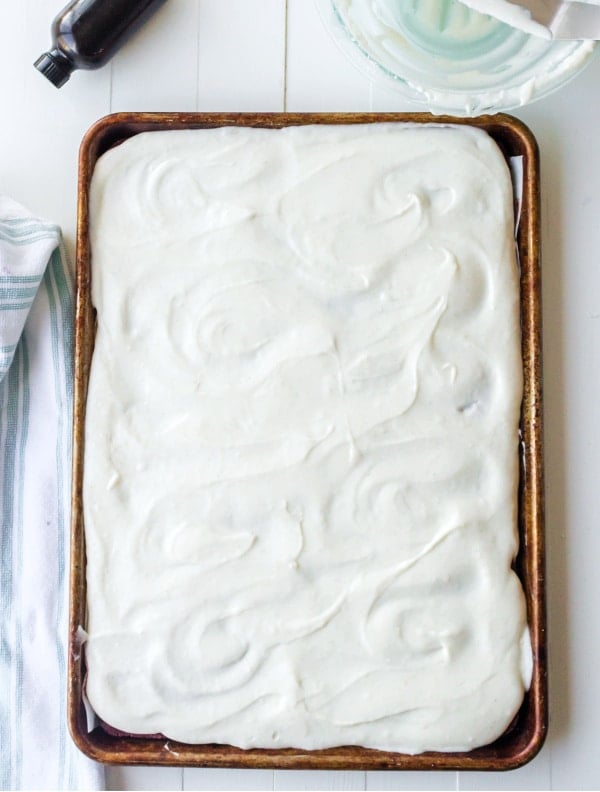 Frosted red velvet cake in a metal baking pan