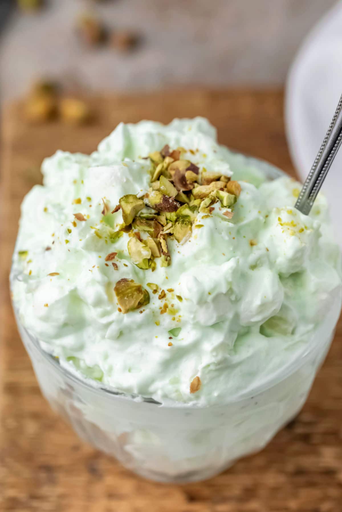 Dish of watergate salad topped with chopped nuts