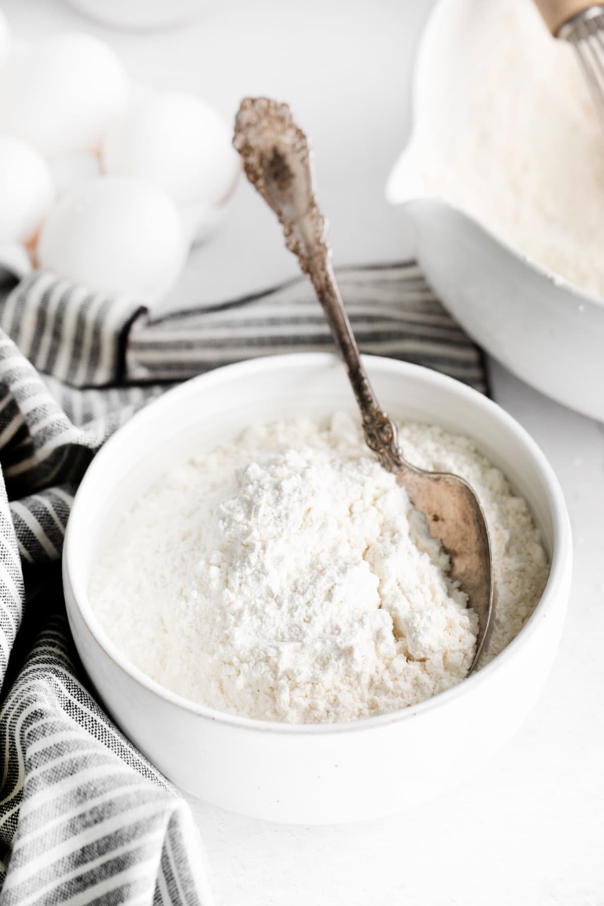 Silver spoon in a bowl of cake flour.