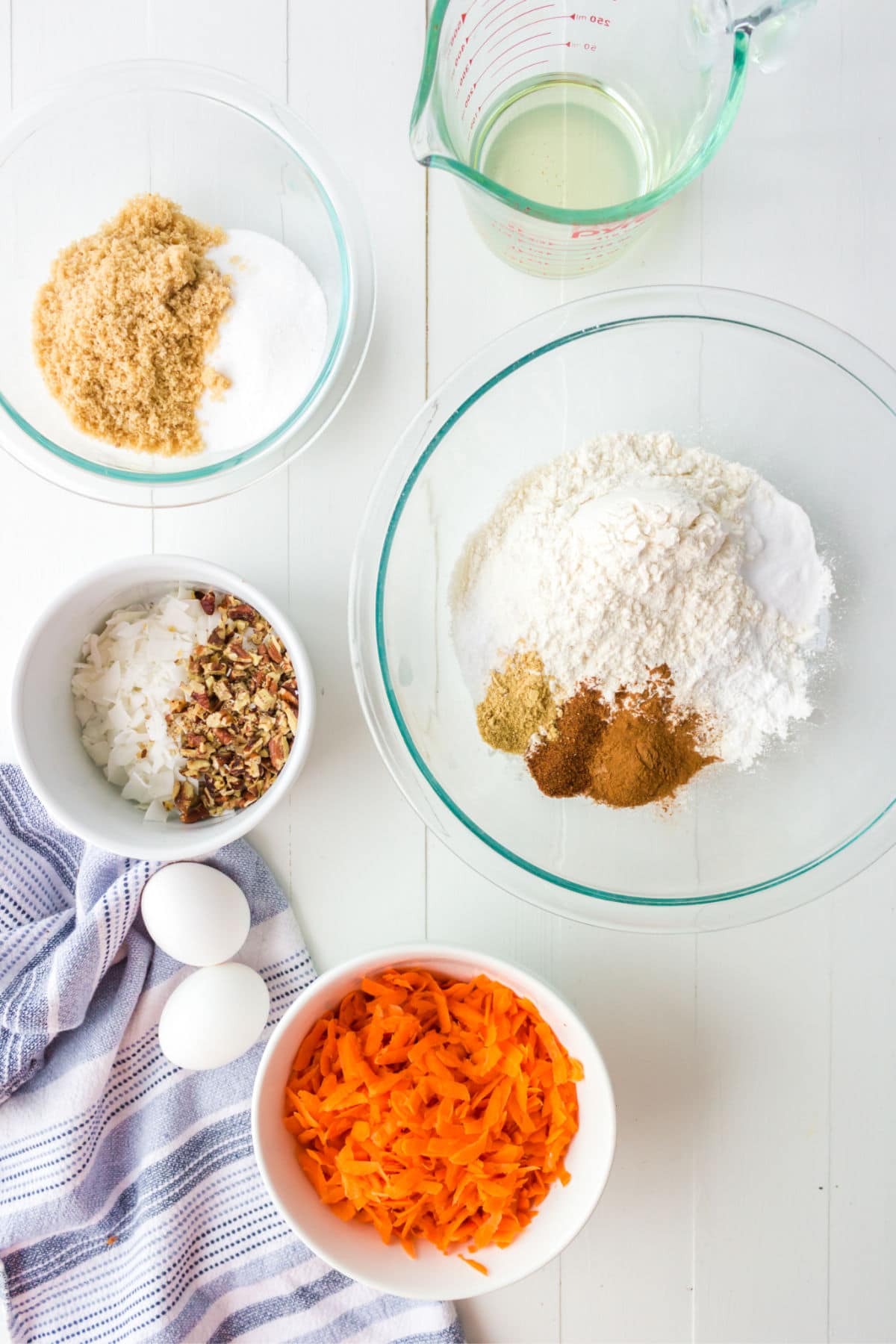 Carrot cake cookie ingredients in glass bowls.