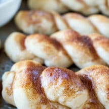 Closeup photo of a cinnamon sugar breadstick on a metal baking pan.