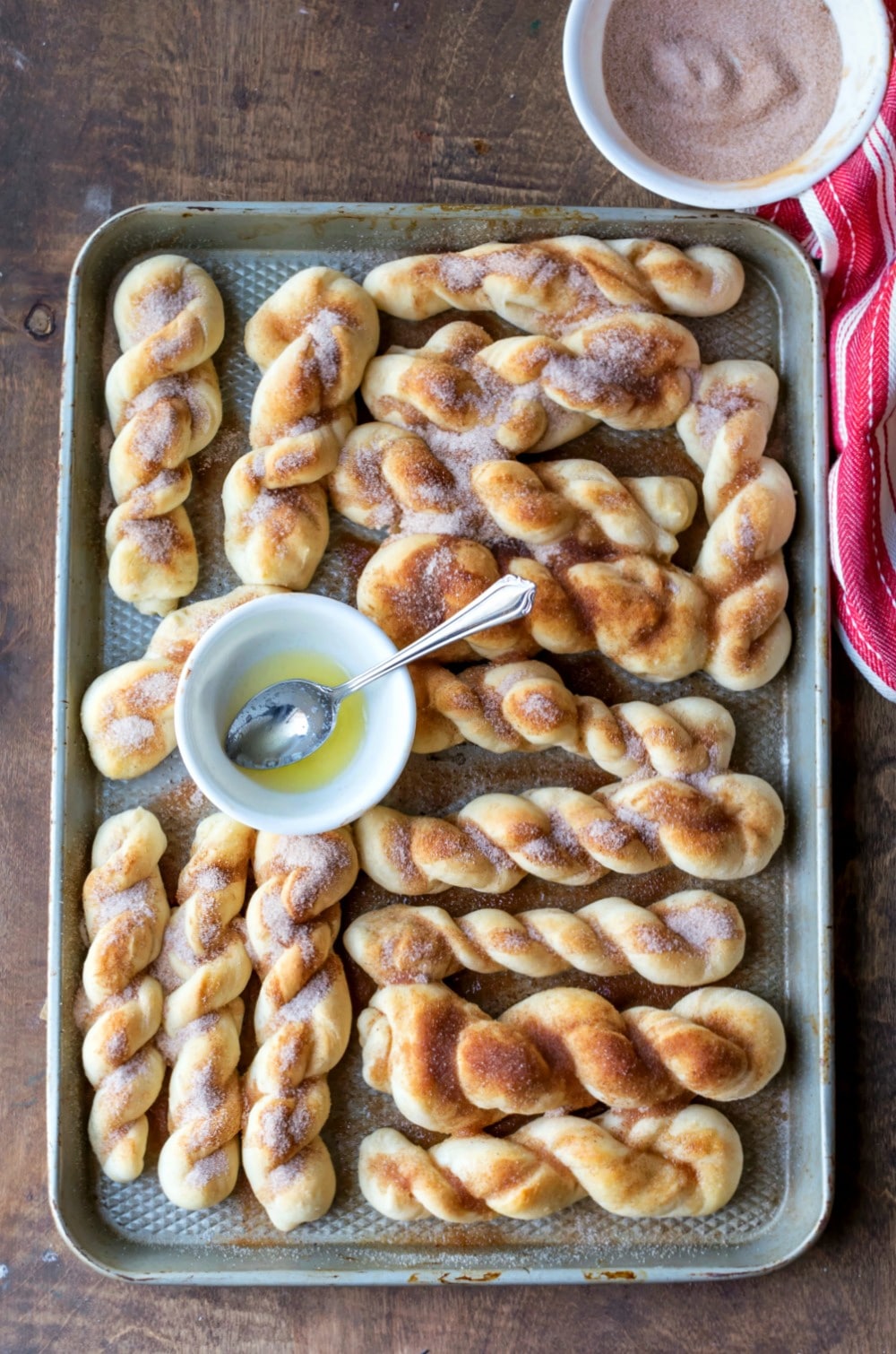 Silver baking pan full of cinnamon sugar breadsticks.