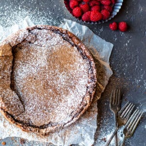 Flourless chocolate cake dusted with cocoa powder and powdered sugar.