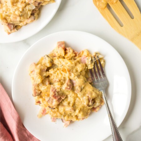 Slow cooker scalloped potatoes with ham on a white plate.