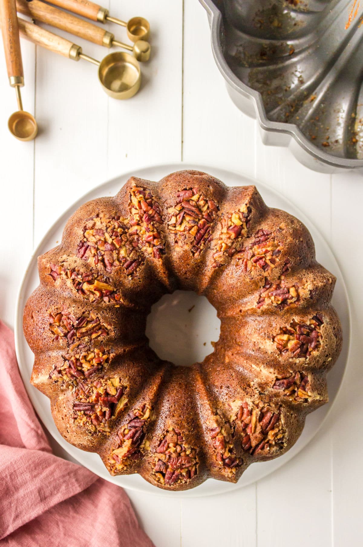 Baked hummingbird bundt cake on a white plate.