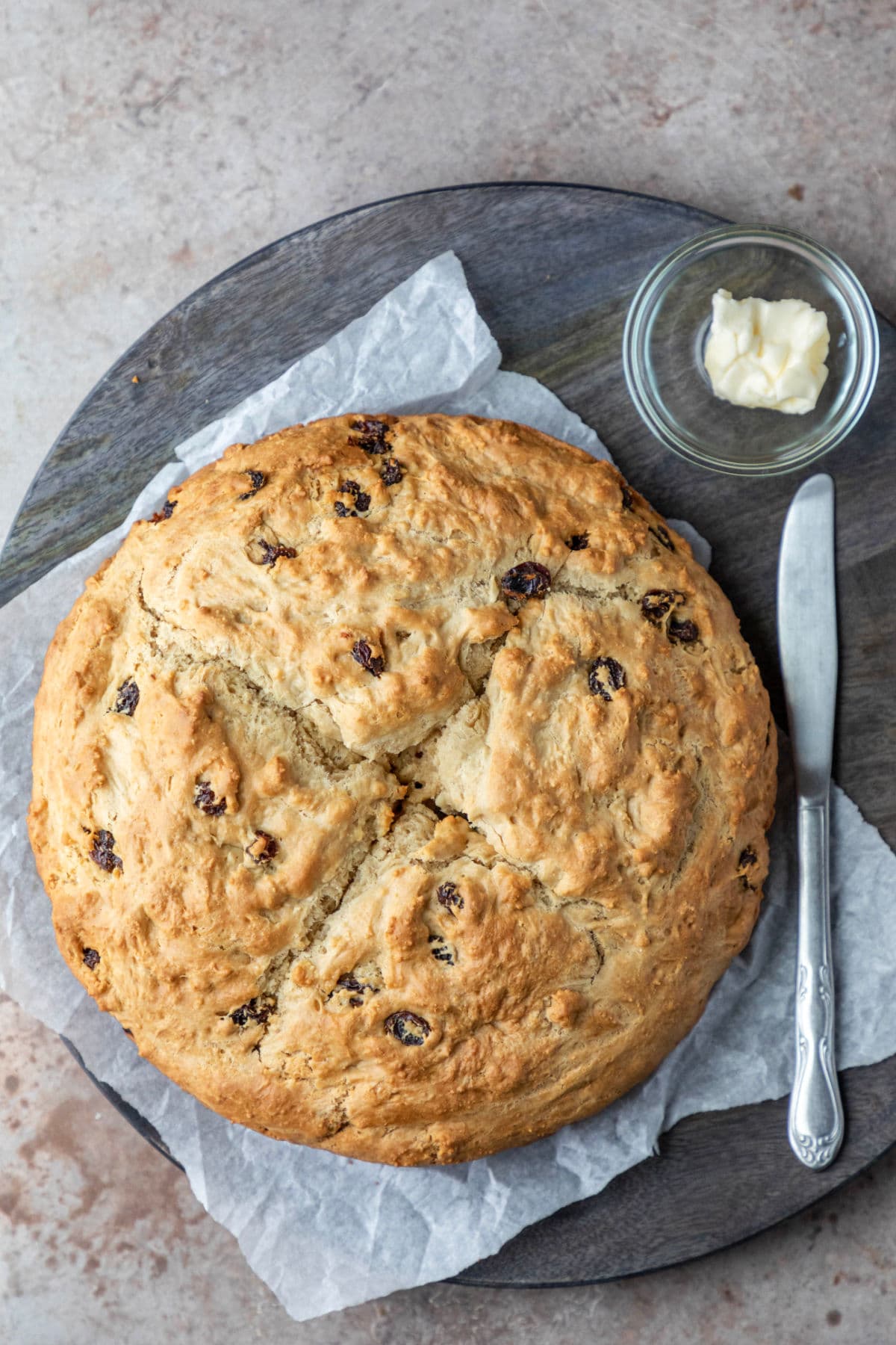 Irish Soda Bread A loaf of Irish soda bread next to a knife and a dish of butter.