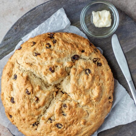 Loaf of Irish soda bread on a piece of parchment paper.