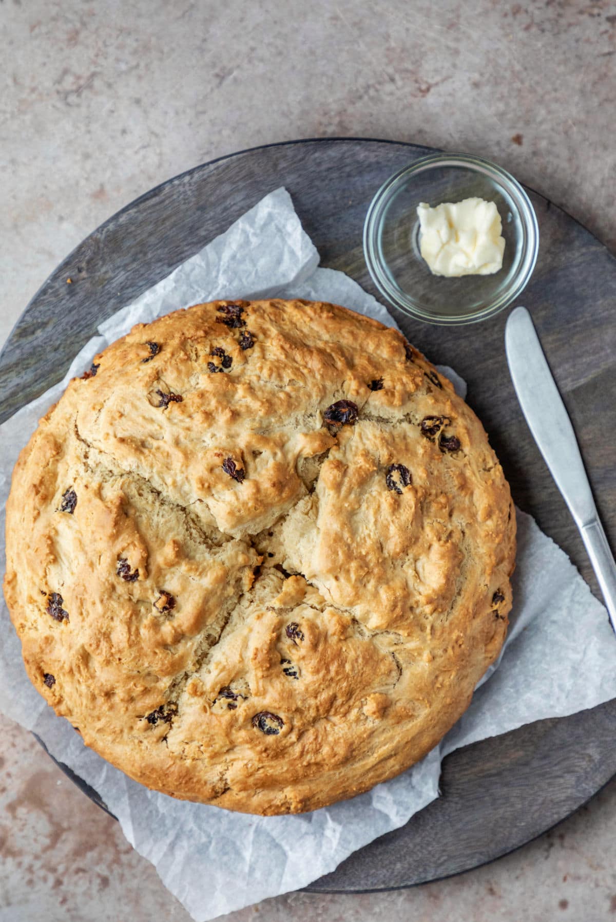 Loaf of Irish soda bread on a piece of parchment paper.