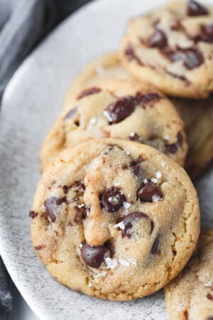 Brown butter chocolate chip cookies lined up on a plate.