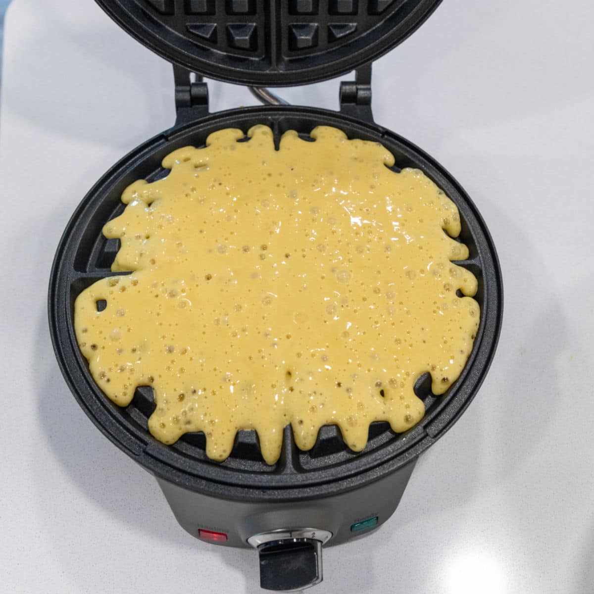 Waffle batter in an open waffle iron.