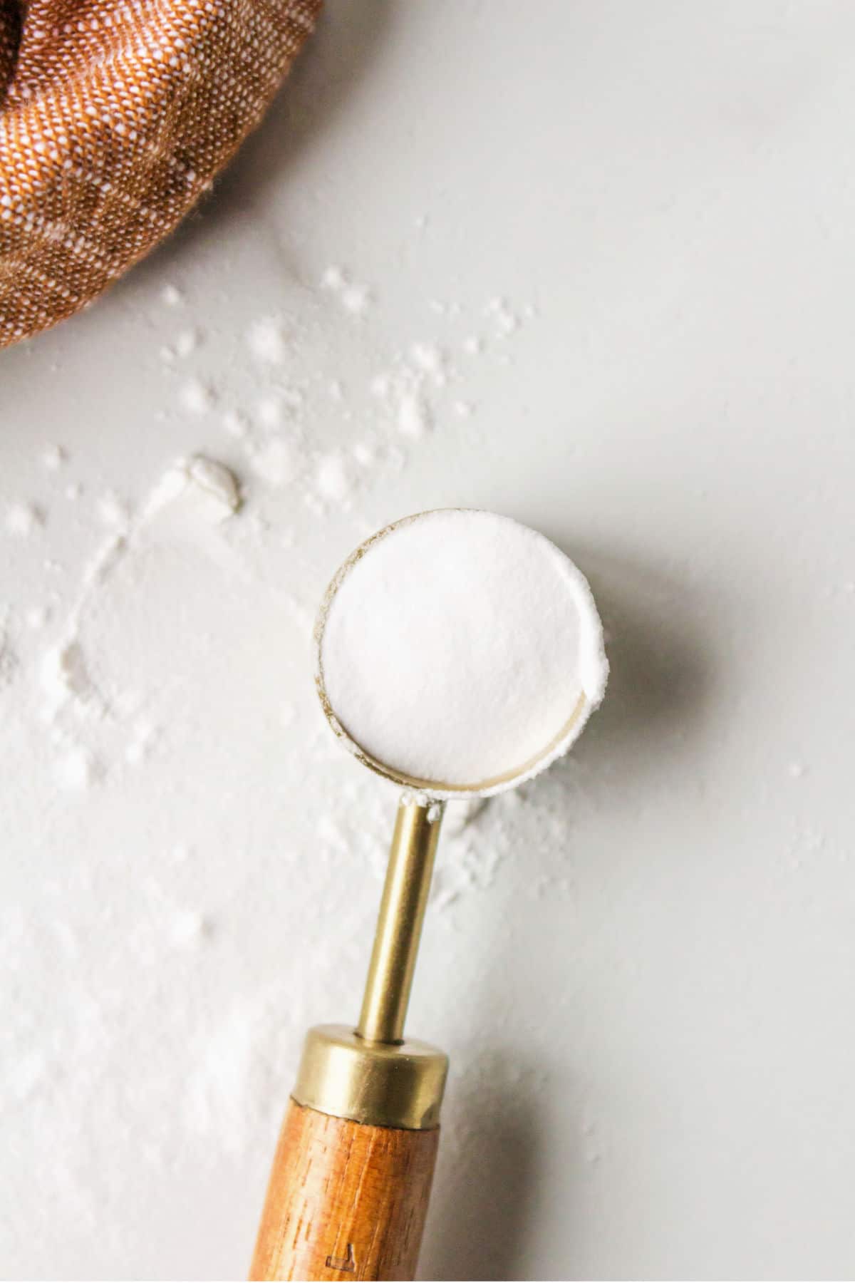 Wooden measuring spoon filled with baking soda. 