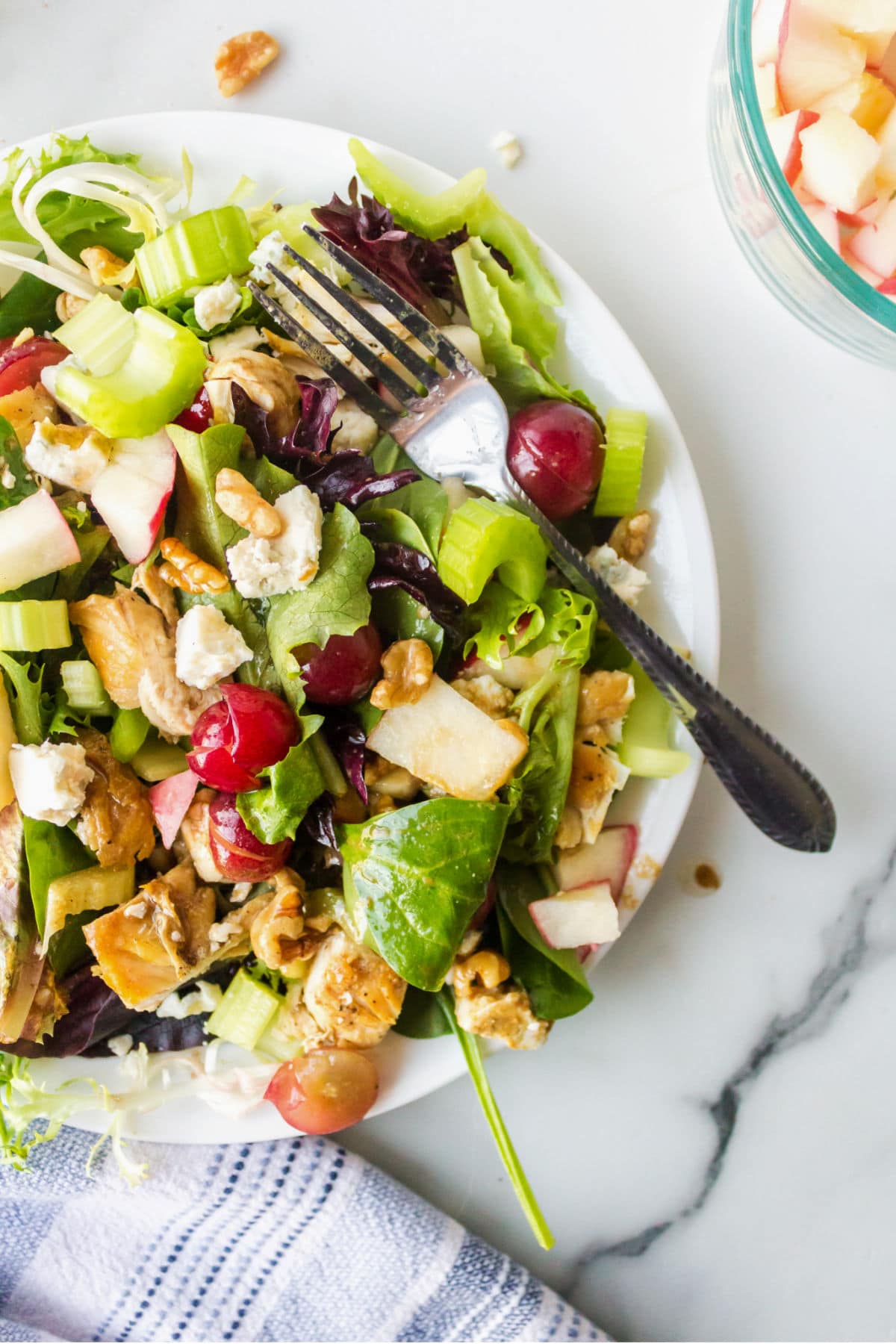 White plate with waldorf salad on a marble background. 