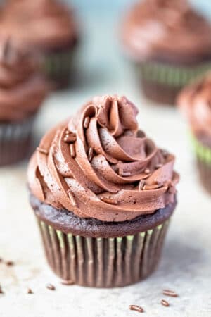 Chocolate cupcake with a swirl of chocolate buttercream frosting and chocolate sprinkles.