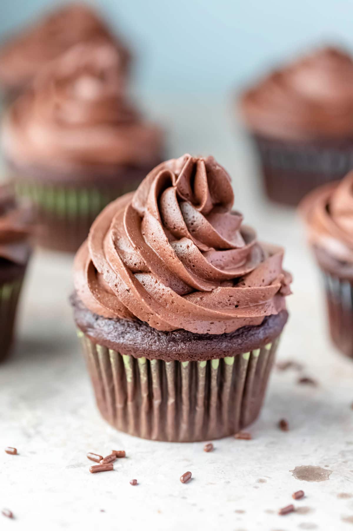 Chocolate cupcake surrounded by other chocolate cupcakes.