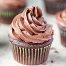 Chocolate cupcake with chocolate frosting next to chocolate sprinkles.