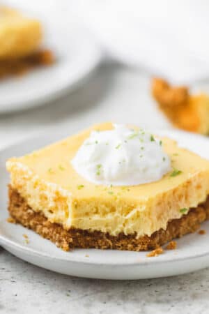 Square photo of key lime pie bar on a white plate.