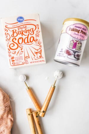 A box of baking soda next to a can of baking powder.