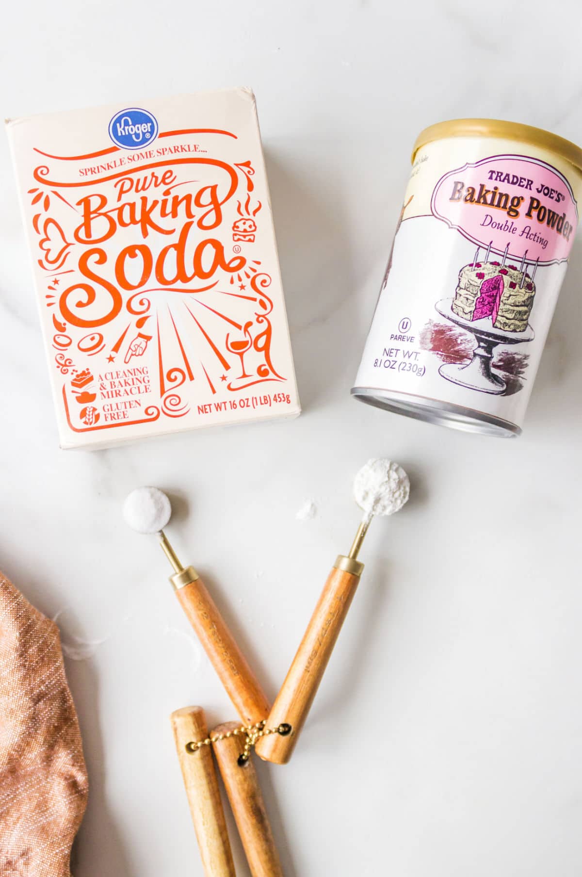 Box of baking soda next to a can of baking powder. 