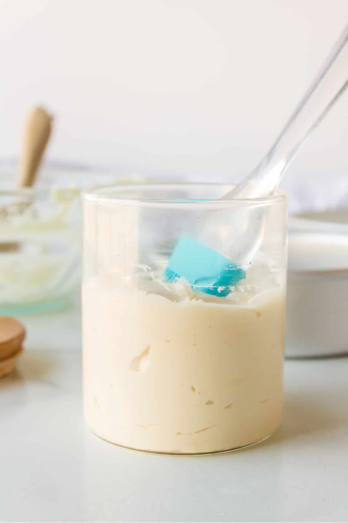 Glass jar filled with pan release with a silicone pastry brush in the jar. 