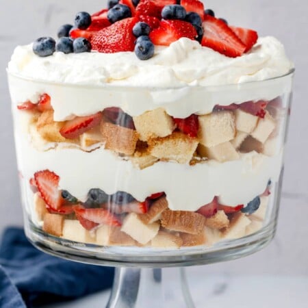 Layers of pound cake whipped cream and fresh berries in a trifle dish.