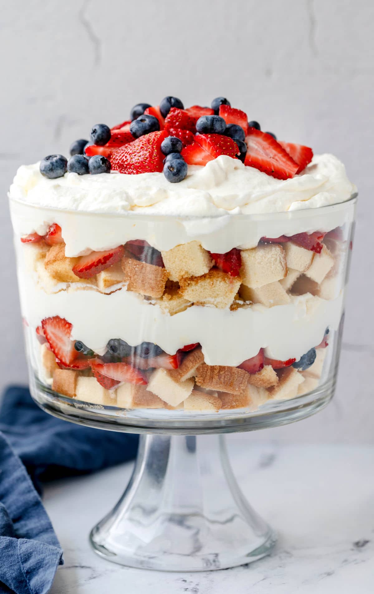 Layers of pound cake whipped cream and fresh berries in a trifle dish.