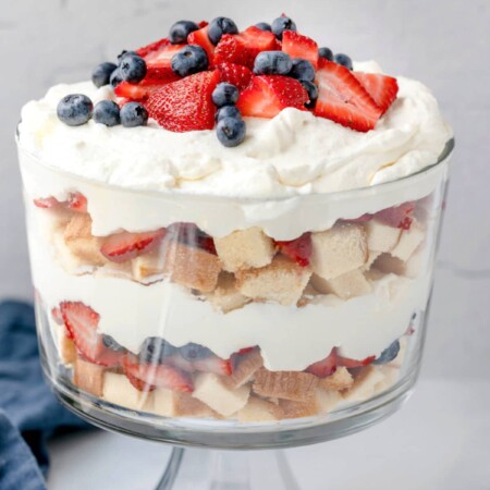 red white and blue trifle in a glass trifle dish on a marble background