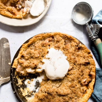 Apple crumb pie topped with a scoop of vanilla ice cream.
