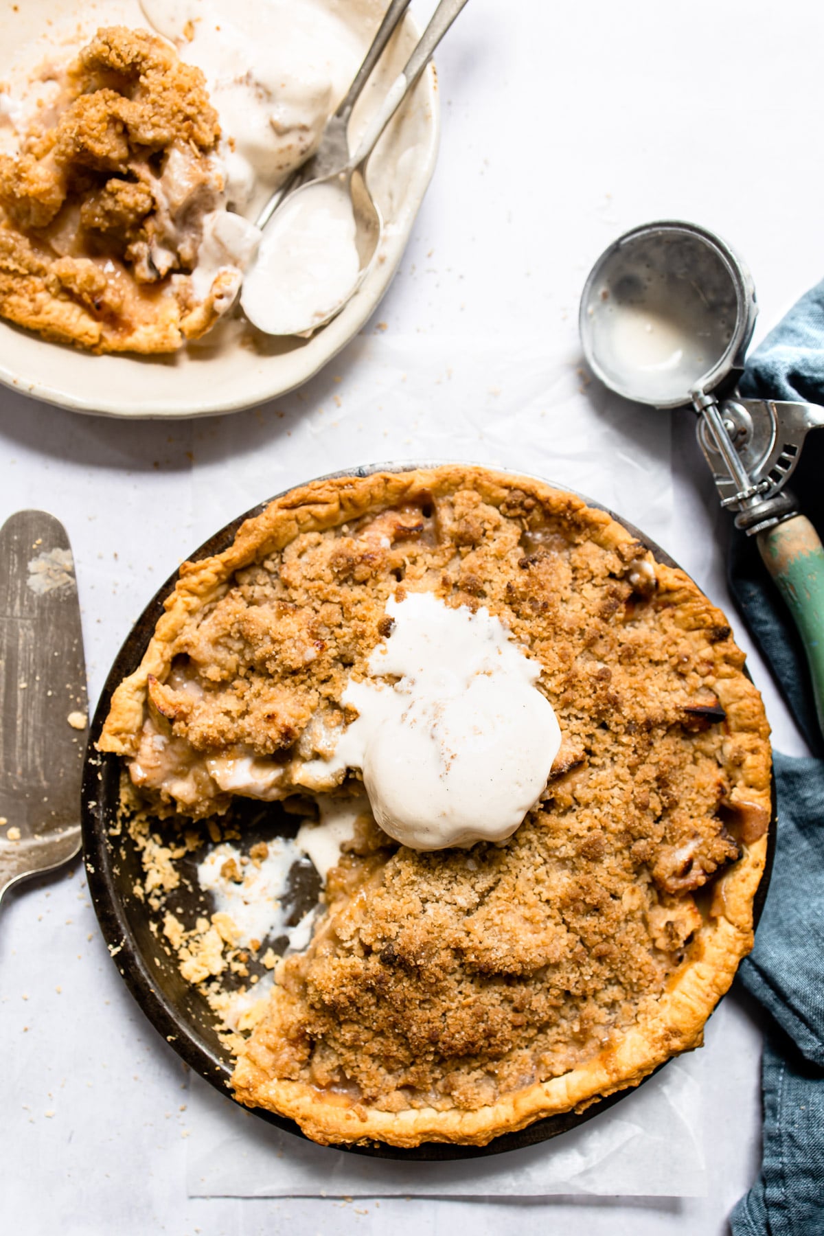 Apple crumb pie topped with a scoop of vanilla ice cream.