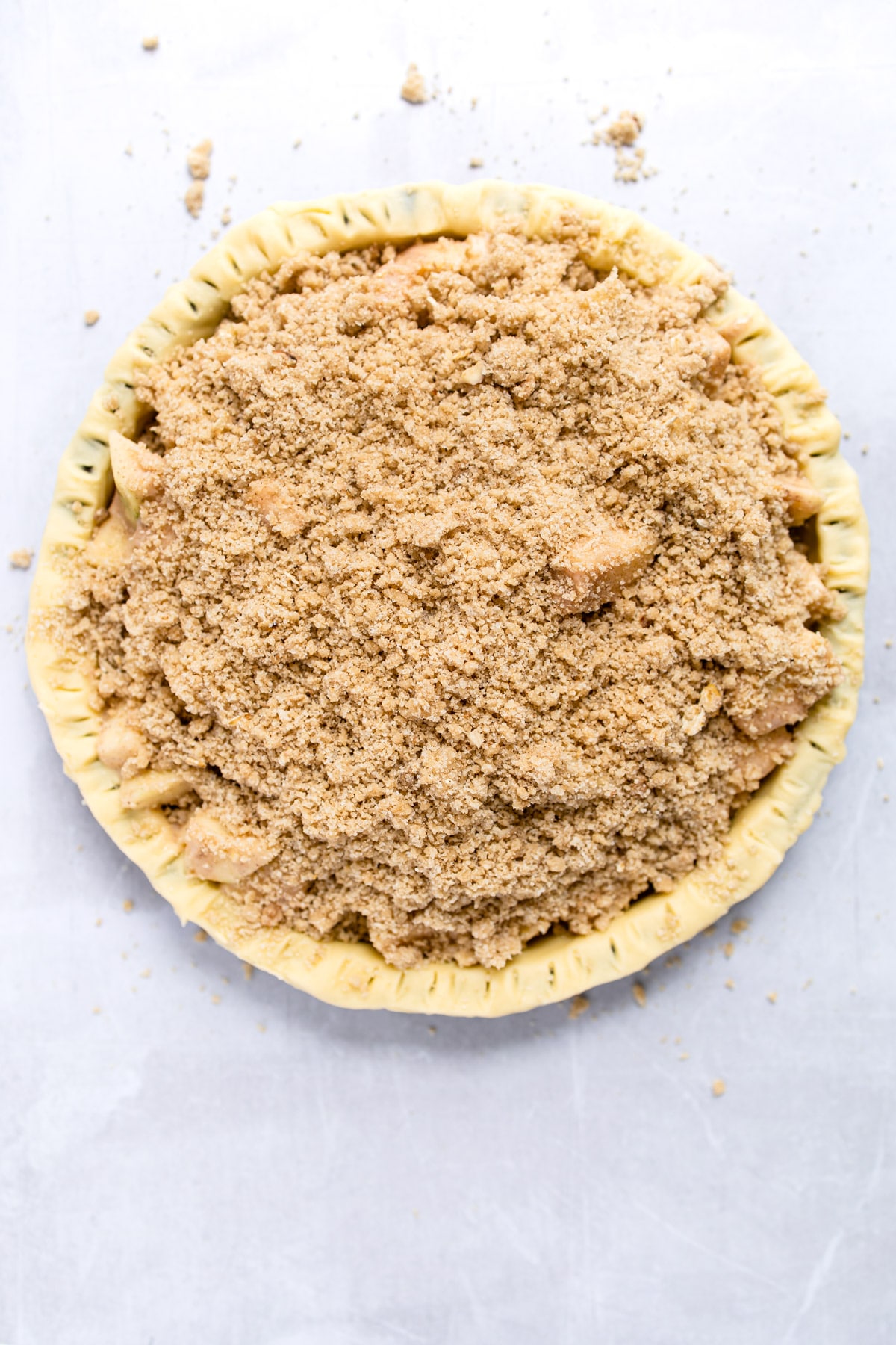 unbaked crumb topping on an unbaked apple crumb pie.