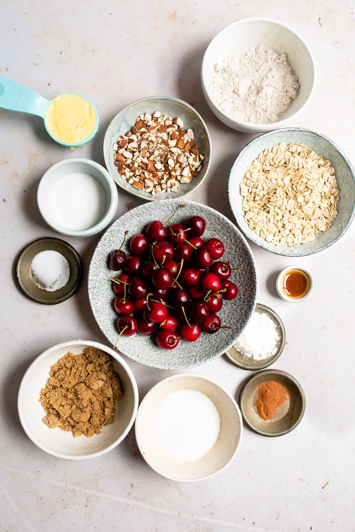 Ingredients for cherry crisp in bowls next to each other. 