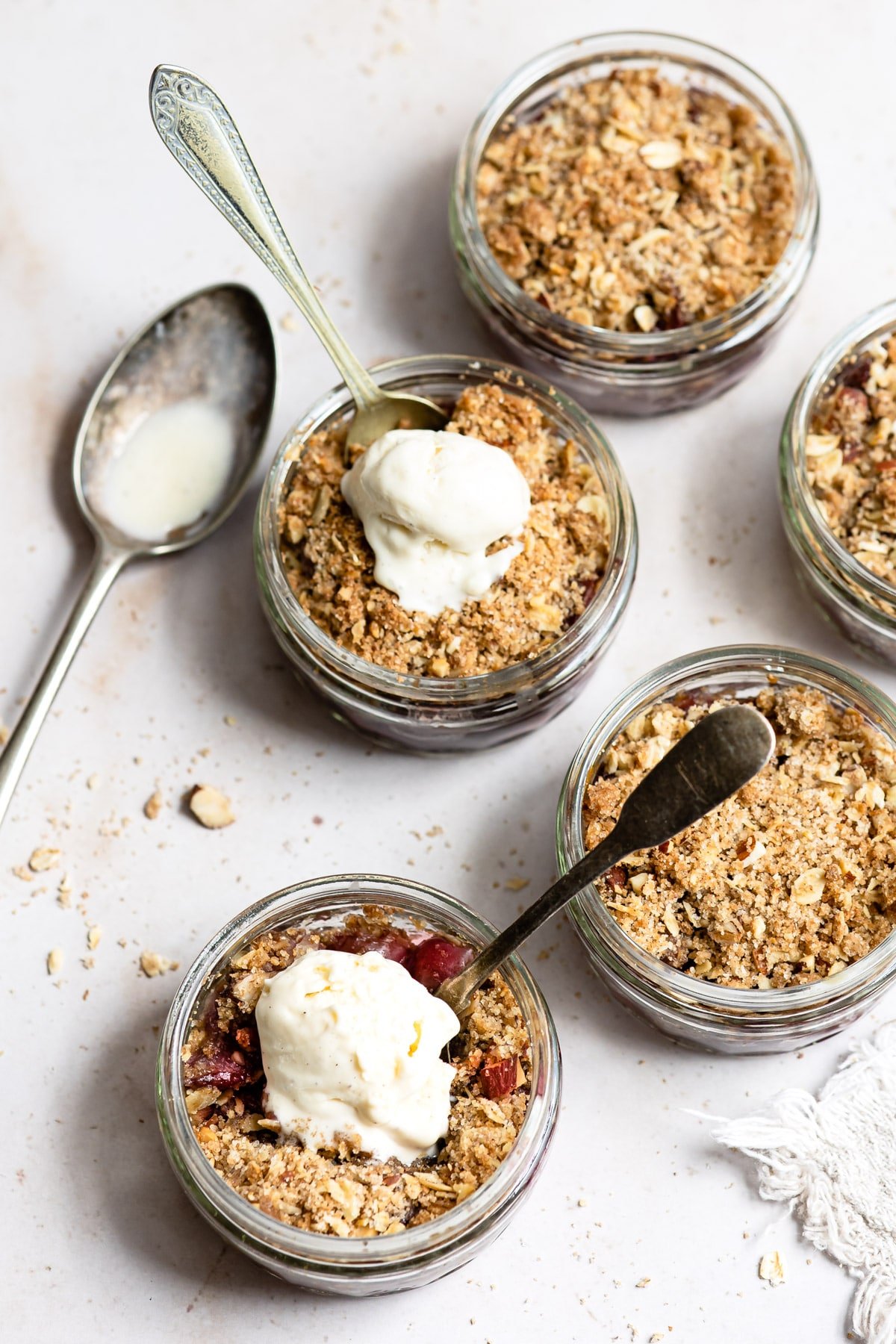 Two ramekins with cherry crisp  topped with vanilla ice cream.