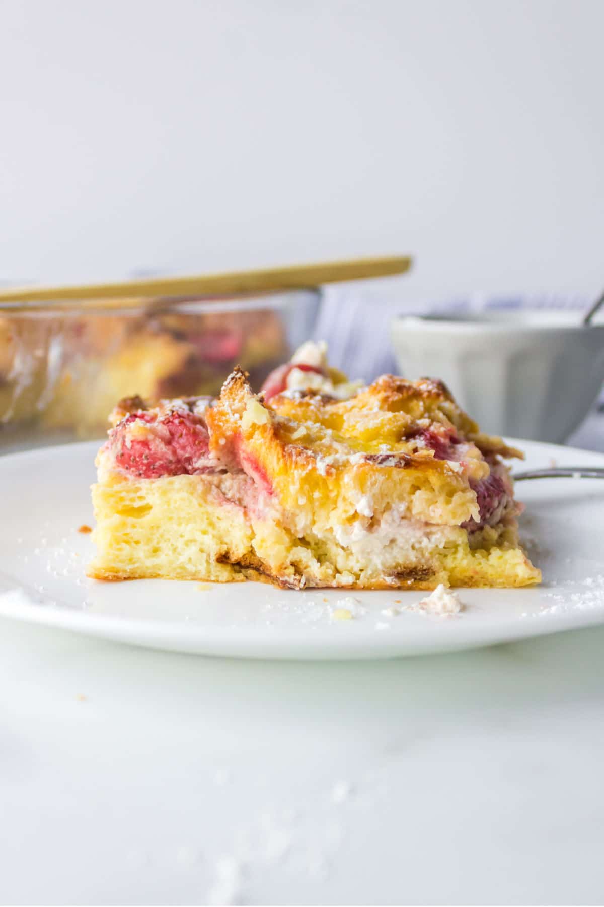 Side view of strawberry cream cheese French toast on a white plate. 