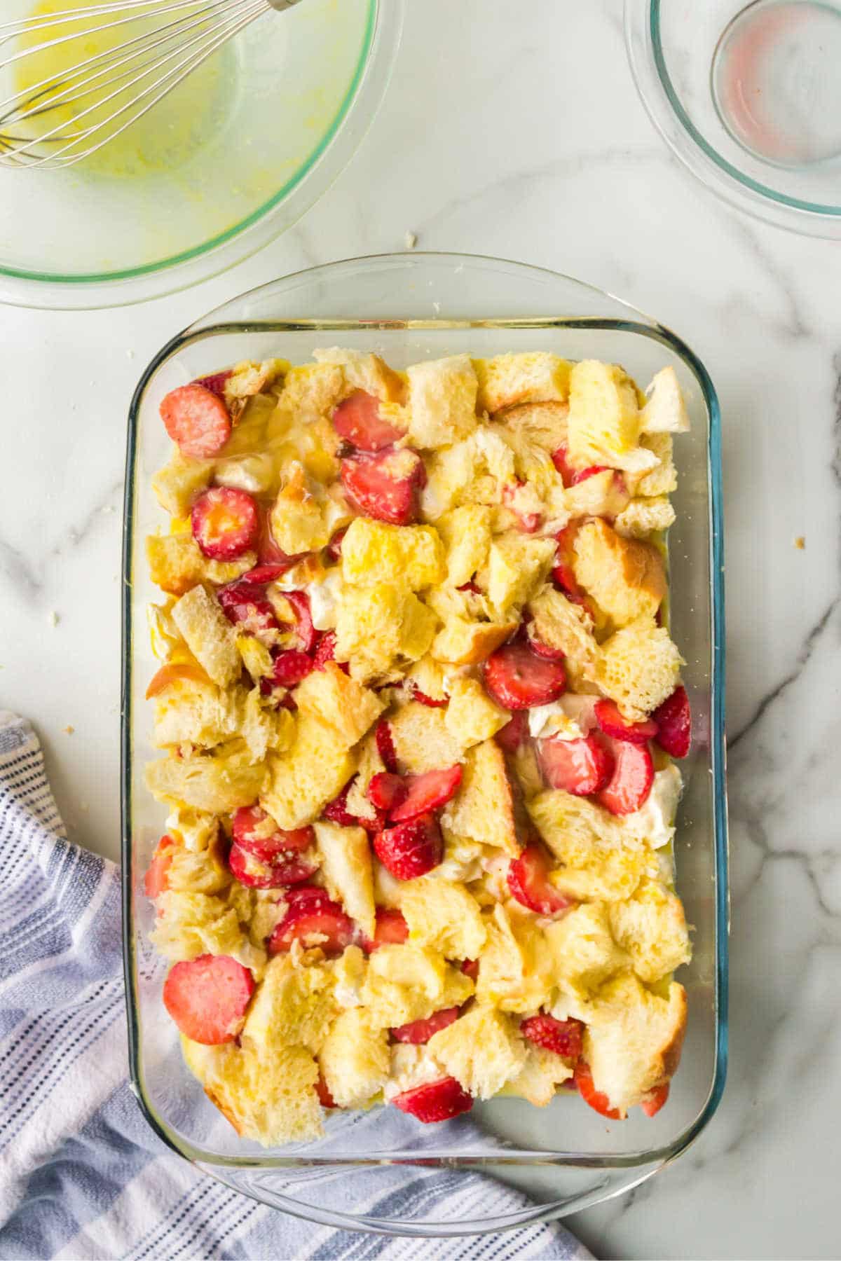 Unbaked strawberry cream cheese French toast in a glass baking pan. 