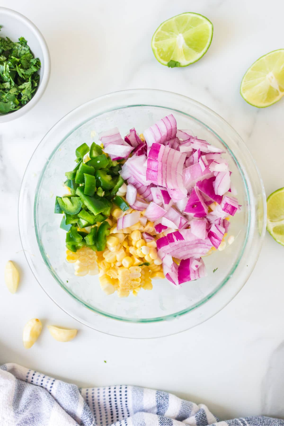 fresh corn red onion and jalapeno in a glass bowl.