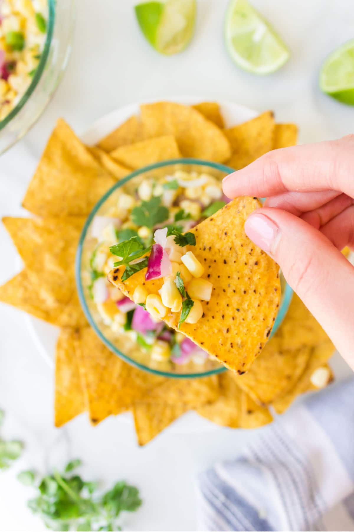 Tortilla chip scooping up fresh corn salsa. 