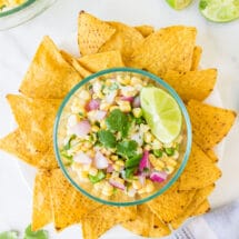 Dish of fresh corn salsa surrounded by tortilla chips.