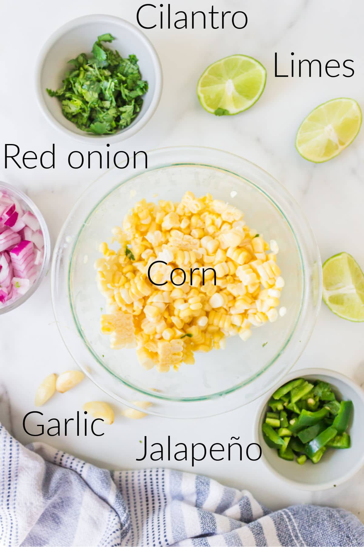 Labeled photo of fresh corn salsa ingredients in dishes.