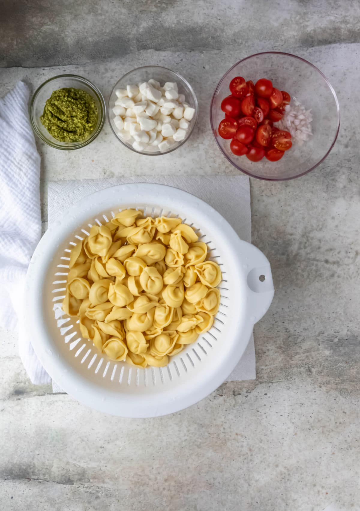 Drained cooked tortellini in a collander.