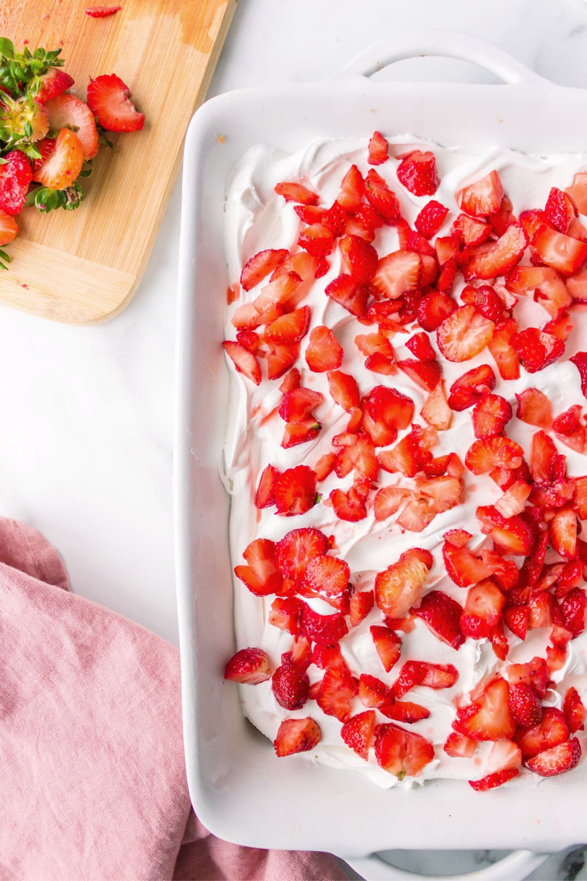 Pan of strawberry shortcake bars next to a pink napkin.