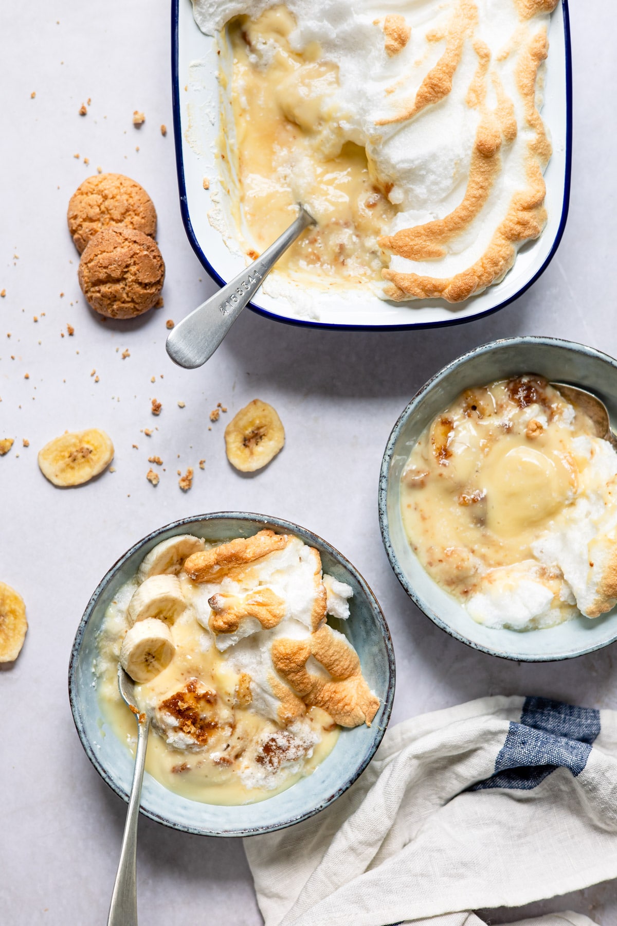 Two dishes of banana pudding next to the baking dish. 