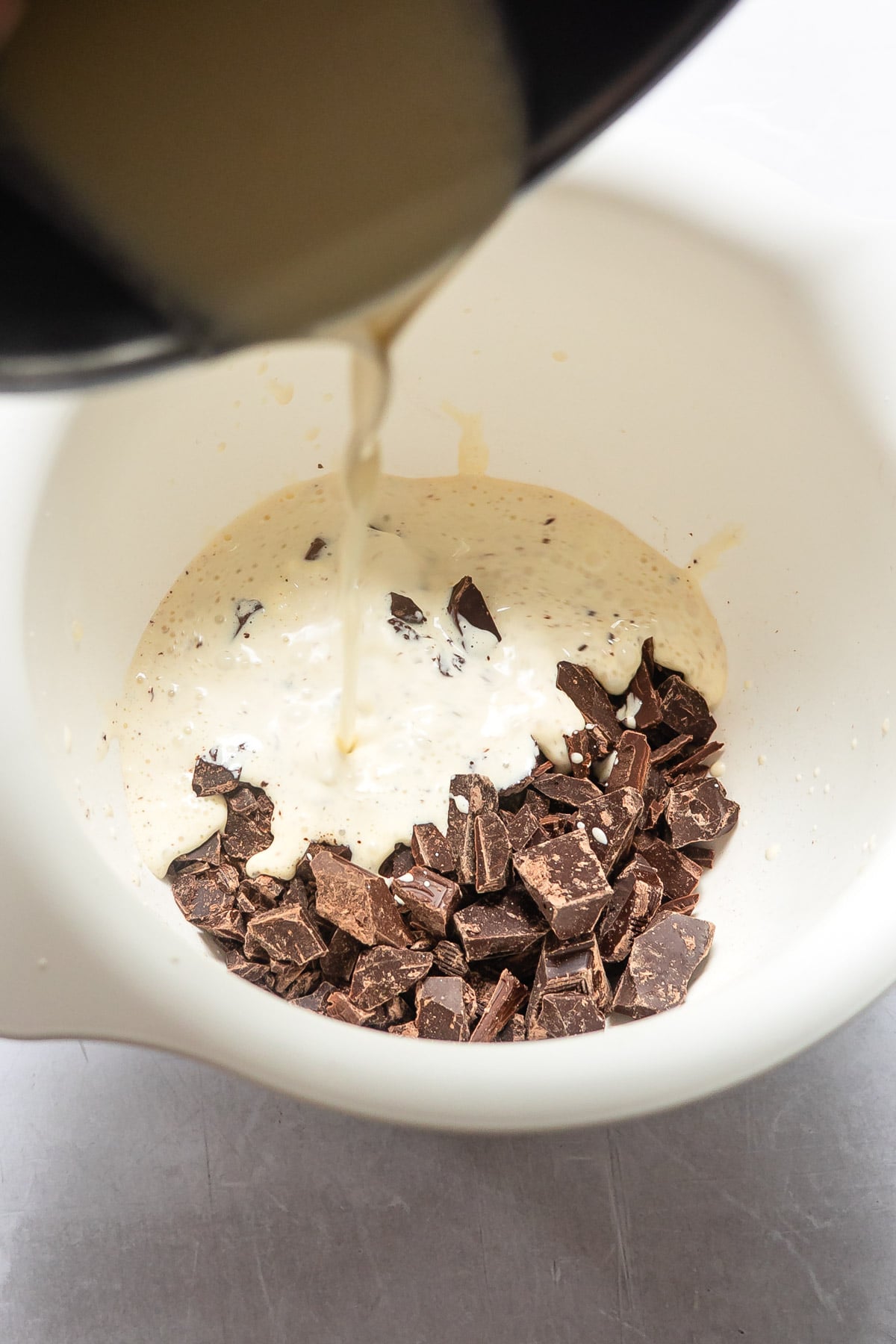Hot cream pouring onto chopped chocolate.