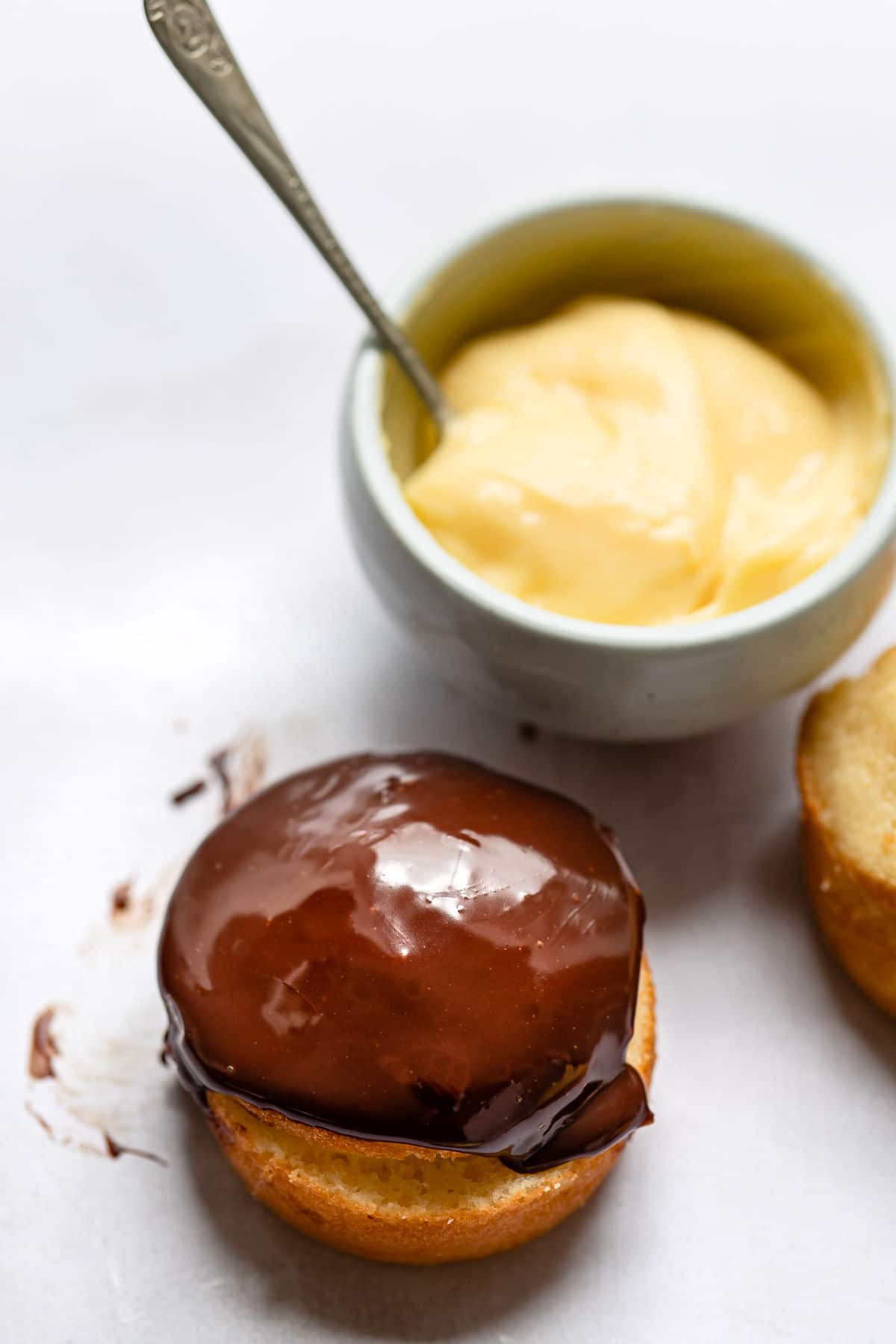 Boston cream pie next to a dish of pastry cream. 