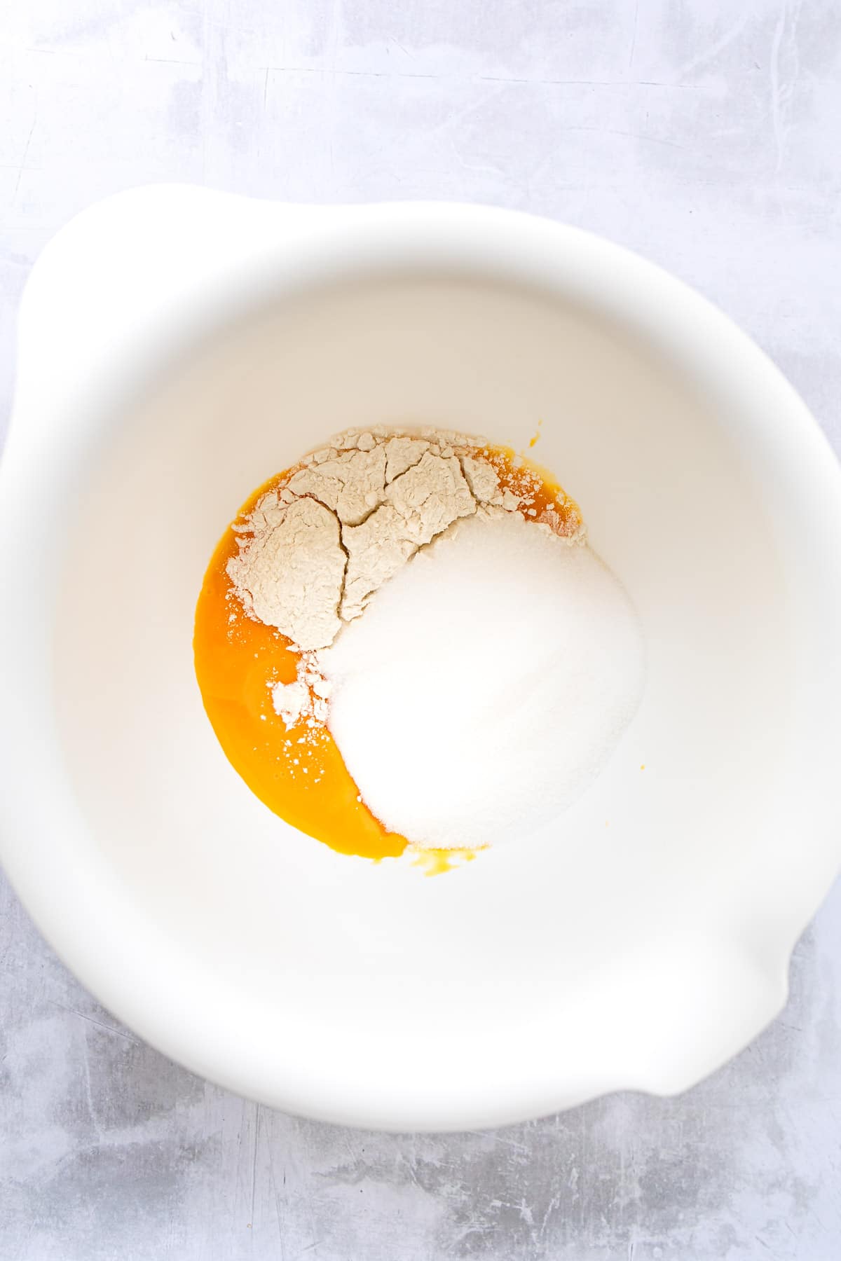 Flour and egg yolks in a mixing bowl.