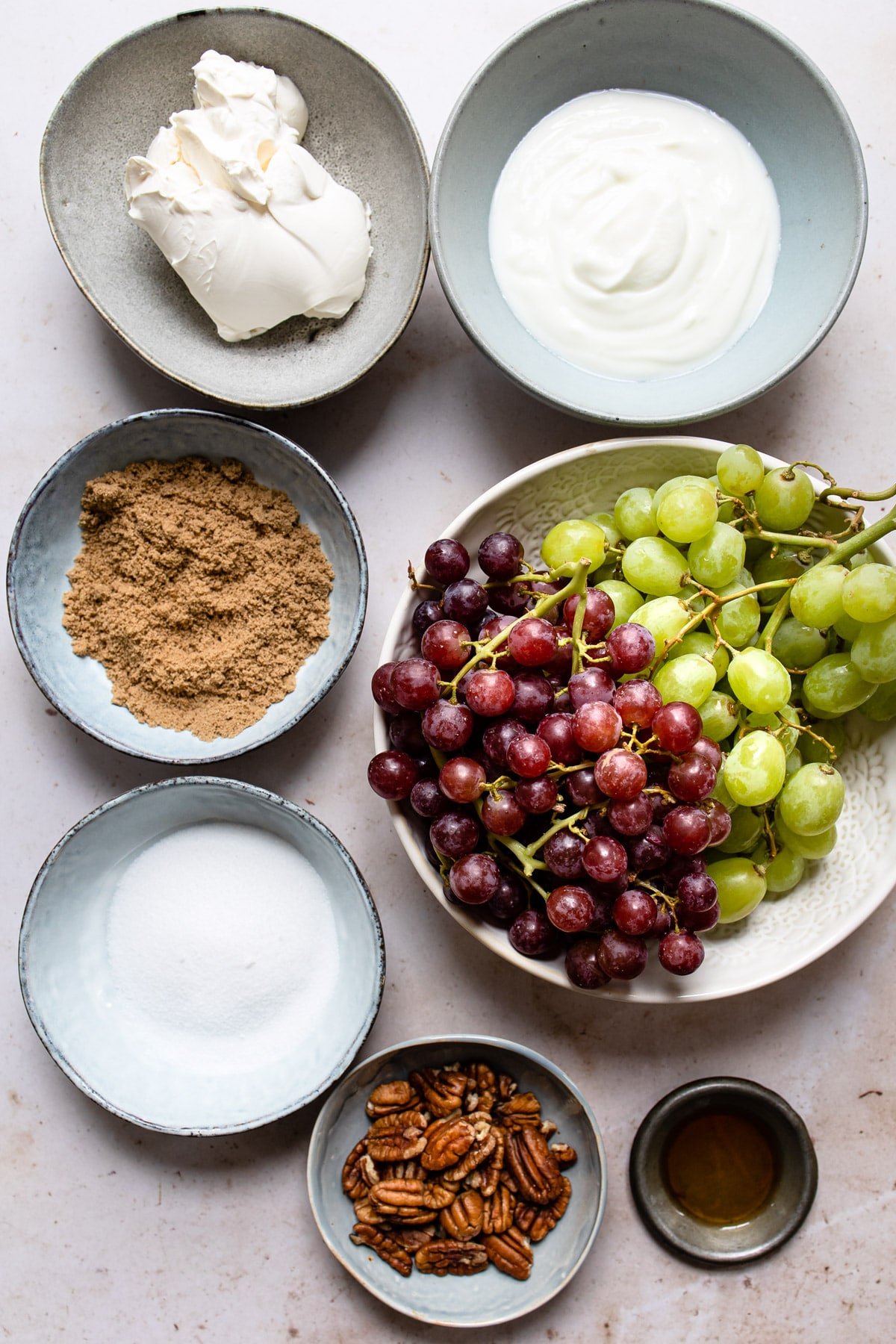 Ingredients for grape salad on plates and in bowls. 